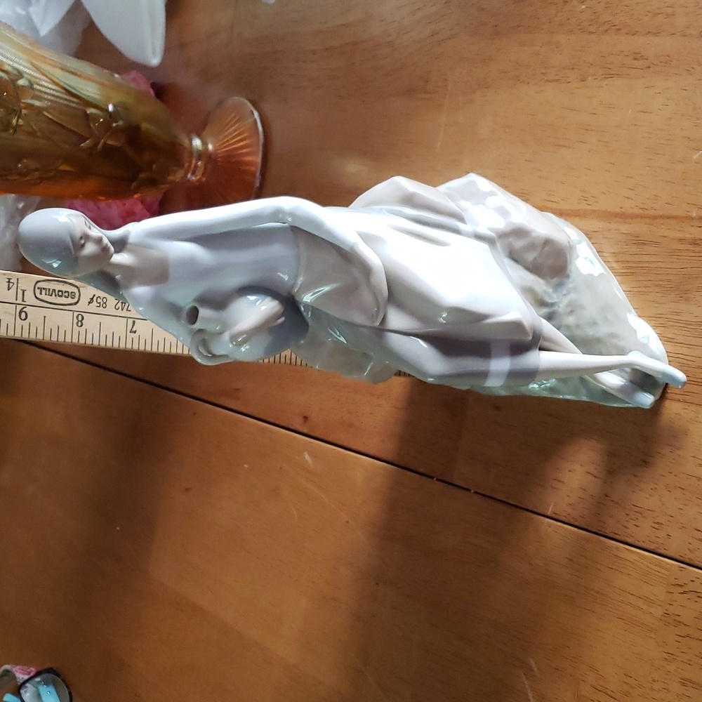 Lladro girl sitting on rocks holding a pitcher, Glazed porcelain